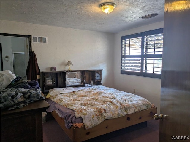 bedroom with a textured ceiling and visible vents