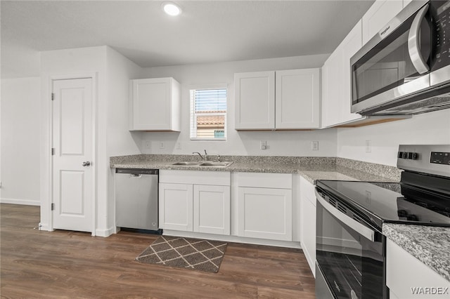 kitchen with white cabinetry, dark wood-style flooring, stainless steel appliances, and a sink