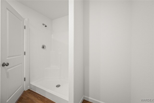 bathroom featuring a shower stall and wood finished floors