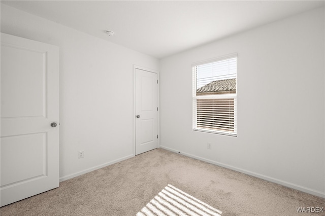 unfurnished bedroom featuring carpet and baseboards