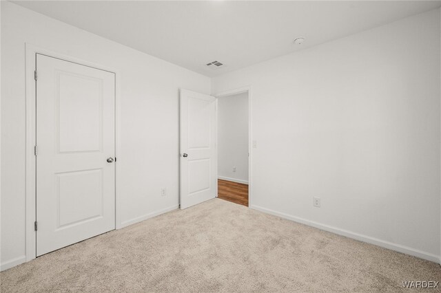 unfurnished bedroom featuring carpet floors, visible vents, and baseboards