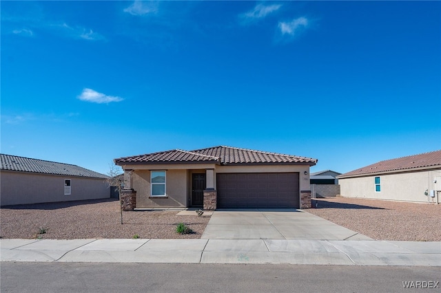 view of front of property featuring a garage, a tile roof, concrete driveway, stone siding, and stucco siding