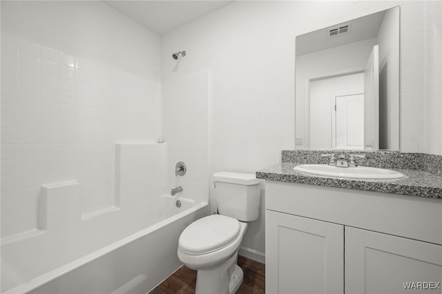 full bath featuring visible vents, toilet, washtub / shower combination, vanity, and wood finished floors