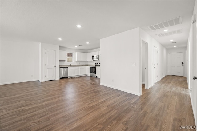 unfurnished living room featuring dark wood-style floors, recessed lighting, visible vents, and baseboards