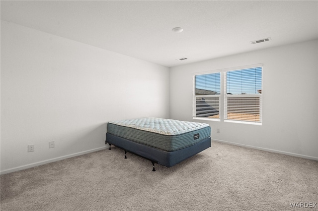 carpeted bedroom featuring visible vents and baseboards