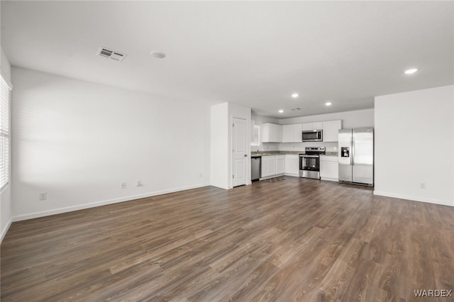 unfurnished living room featuring dark wood-style floors, recessed lighting, visible vents, and baseboards