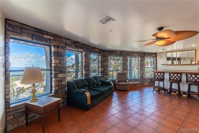 living room featuring ceiling fan, visible vents, and tile patterned floors