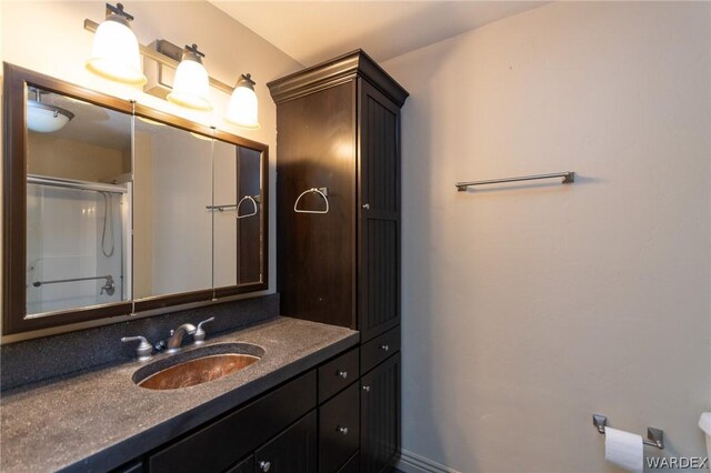 full bathroom featuring a shower with door and vanity