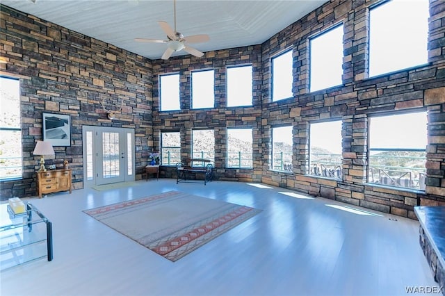 interior space with ceiling fan and a high ceiling