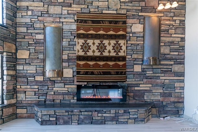 room details with an outdoor stone fireplace and wood finished floors