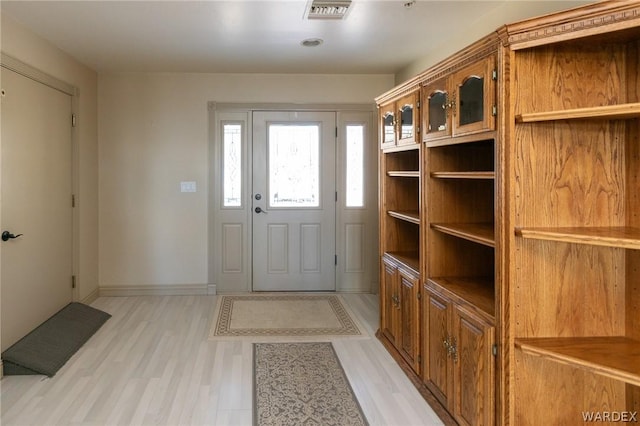 interior space with light wood-type flooring, visible vents, and baseboards