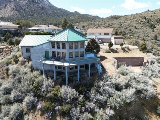 rear view of property with metal roof, a mountain view, and a standing seam roof