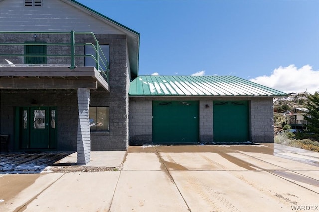 view of front of property with a standing seam roof, metal roof, and a balcony