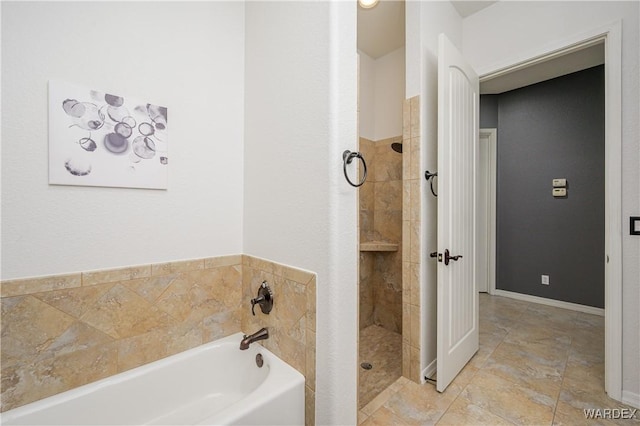 full bath featuring a stall shower, baseboards, and a bath