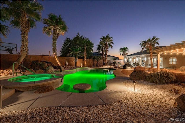 view of pool featuring a pool with connected hot tub and fence