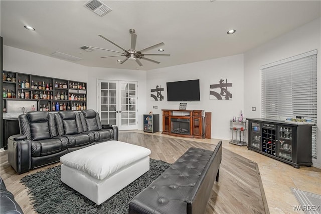 living area with wet bar, french doors, visible vents, and recessed lighting