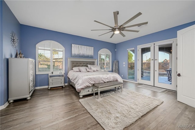 bedroom with access to exterior, french doors, baseboards, and wood finished floors