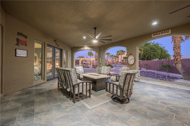 view of patio with ceiling fan, fence, and a fire pit