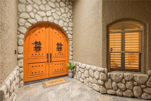 entrance to property with stucco siding