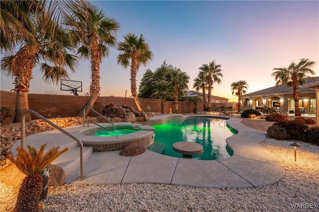 view of swimming pool featuring a pool with connected hot tub, a fenced backyard, and a patio