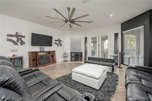 living area with light wood-type flooring, recessed lighting, a ceiling fan, and french doors