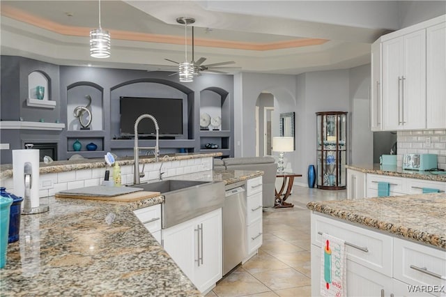 kitchen featuring white cabinetry, a tray ceiling, and open floor plan