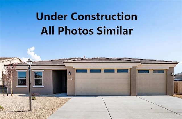3536 Charleston Loop, Kingman, AZ 86401 - prairie-style house with driveway, stucco siding, a garage, and a tile roof