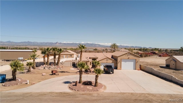 view of front of home with a residential view, curved driveway, a mountain view, and a tiled roof