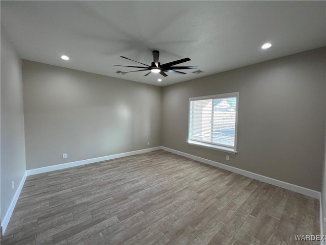 spare room featuring light wood-style flooring, recessed lighting, visible vents, a ceiling fan, and baseboards