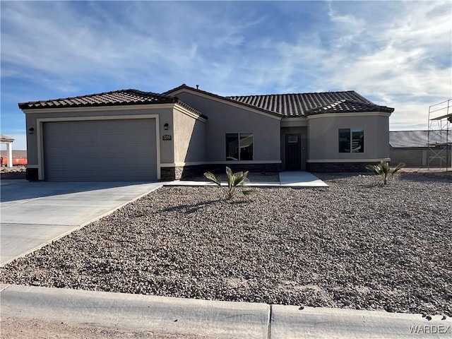 view of front of house featuring driveway, an attached garage, a tile roof, and stucco siding