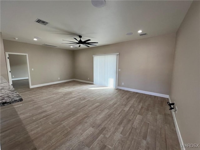 unfurnished room featuring visible vents, ceiling fan, baseboards, and wood finished floors