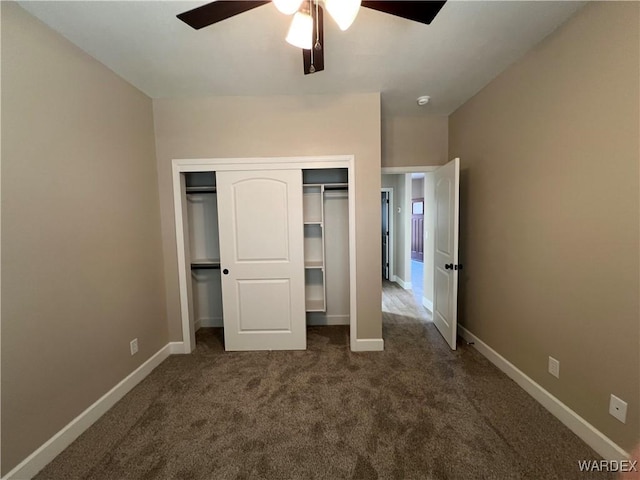 unfurnished bedroom featuring a ceiling fan, baseboards, dark colored carpet, and a closet