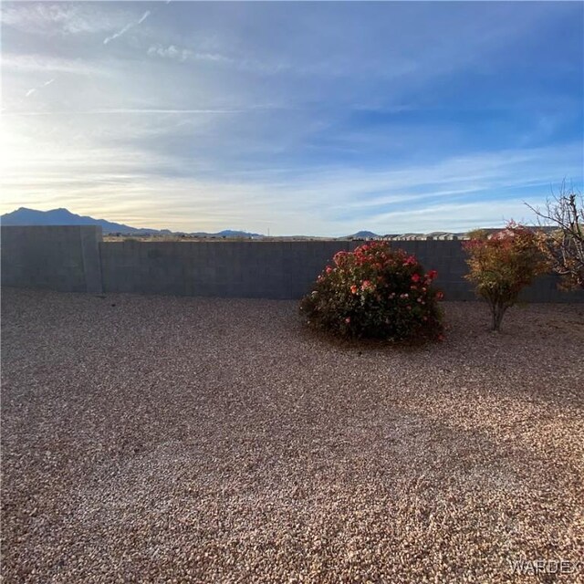 view of yard featuring a mountain view and fence