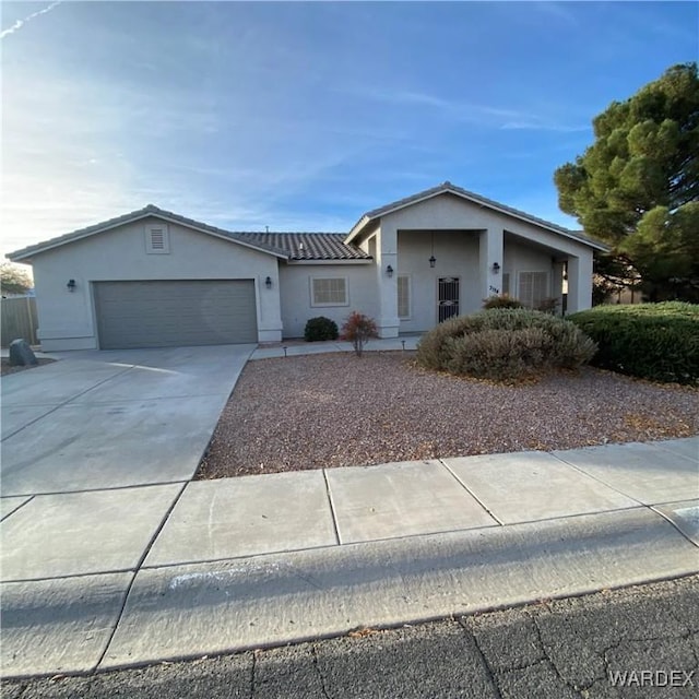 ranch-style house with concrete driveway, an attached garage, and stucco siding