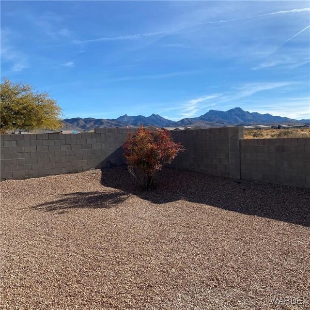 view of yard with a fenced backyard and a mountain view