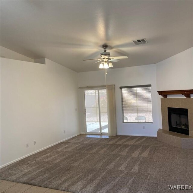 unfurnished living room with light colored carpet, visible vents, a fireplace, and baseboards