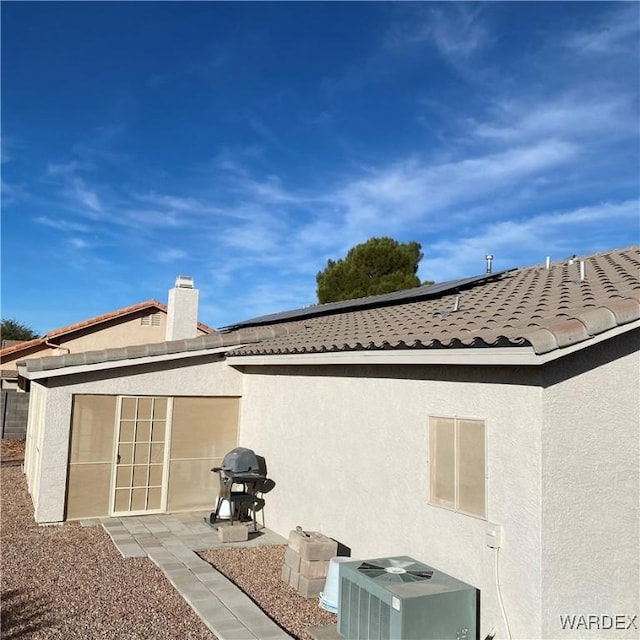 back of property featuring central air condition unit, a tile roof, a patio, and stucco siding