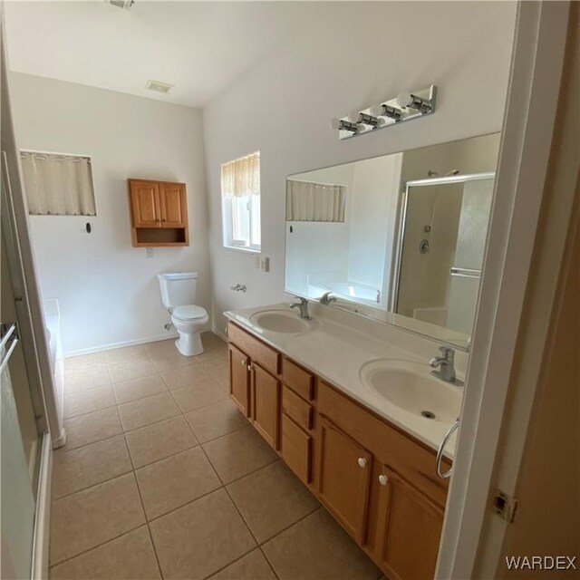 bathroom with tile patterned flooring, visible vents, a sink, and a shower stall