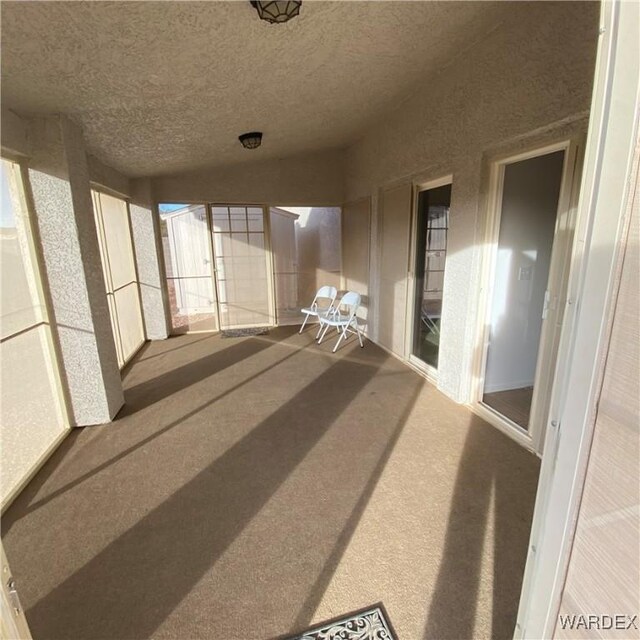 unfurnished sunroom featuring vaulted ceiling