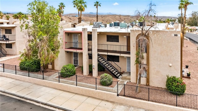 1280 Mohave Dr Unit 28, Bullhead City, AZ 86442 - view of building exterior with stairway, fence, and a mountain view