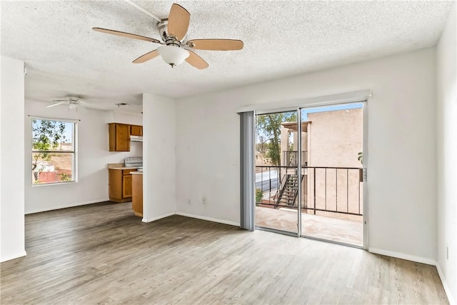 1280 Mohave Dr Unit 28, Bullhead City, AZ 86442 - unfurnished living room with light wood-type flooring, a ceiling fan, a textured ceiling, and baseboards