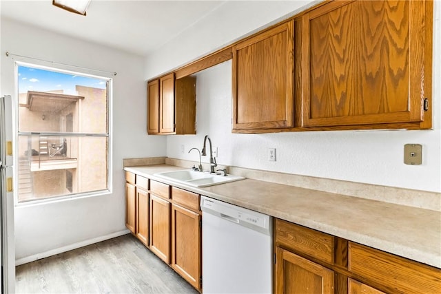 1280 Mohave Dr Unit 28, Bullhead City, AZ 86442 - kitchen featuring white dishwasher, a sink, light wood-style floors, light countertops, and brown cabinets