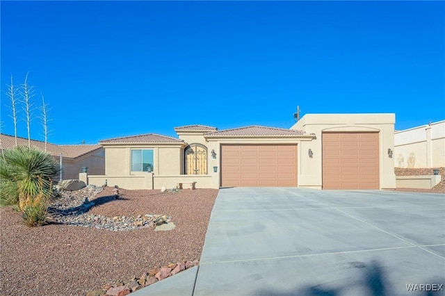 view of front of house with a garage, concrete driveway, a tiled roof, and stucco siding