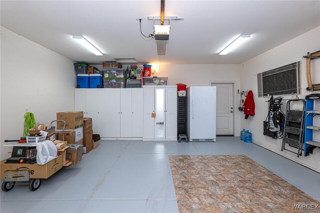 garage featuring a garage door opener and freestanding refrigerator