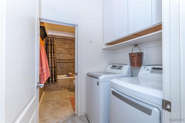 washroom with separate washer and dryer and cabinet space