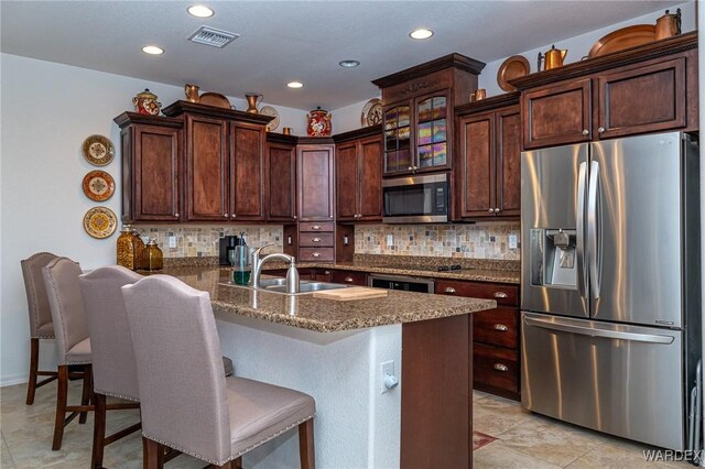 kitchen featuring a breakfast bar, tasteful backsplash, a peninsula, and stainless steel appliances