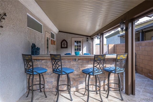 view of patio / terrace featuring fence and outdoor dry bar