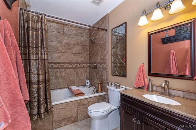 full bathroom featuring toilet, visible vents, vanity, tiled shower / bath, and ornamental molding