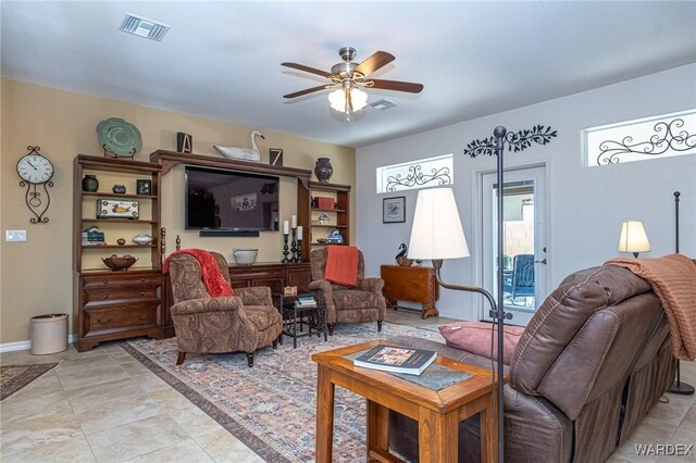 living area featuring ceiling fan, visible vents, and baseboards