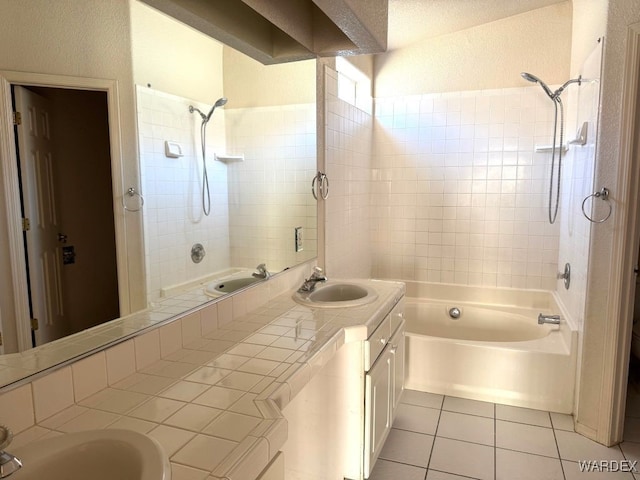 bathroom with tile patterned flooring, washtub / shower combination, and a sink